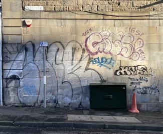 Eyre Terrace street-name sign above a sunlit wall covered in graffiti.