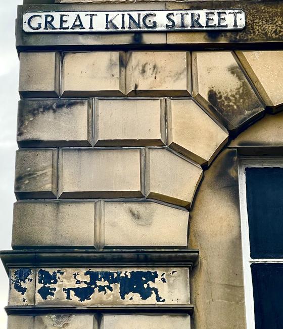 Two worn signs and discoloured masonry.